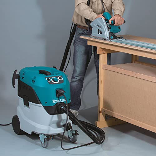 Makita extractor connected by a hose to a track saw on a workbench